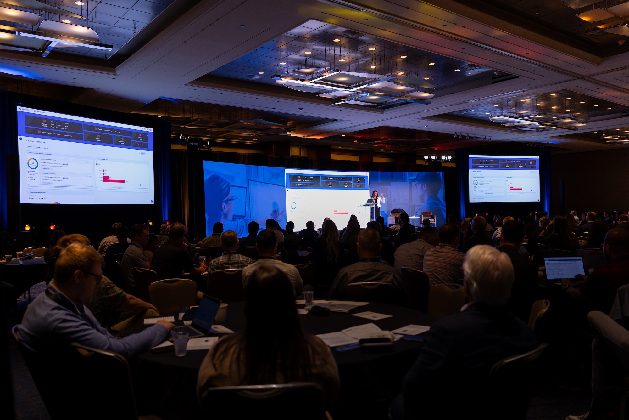 The My Workspace dashboard is shown on large screens during a conference presentation.
