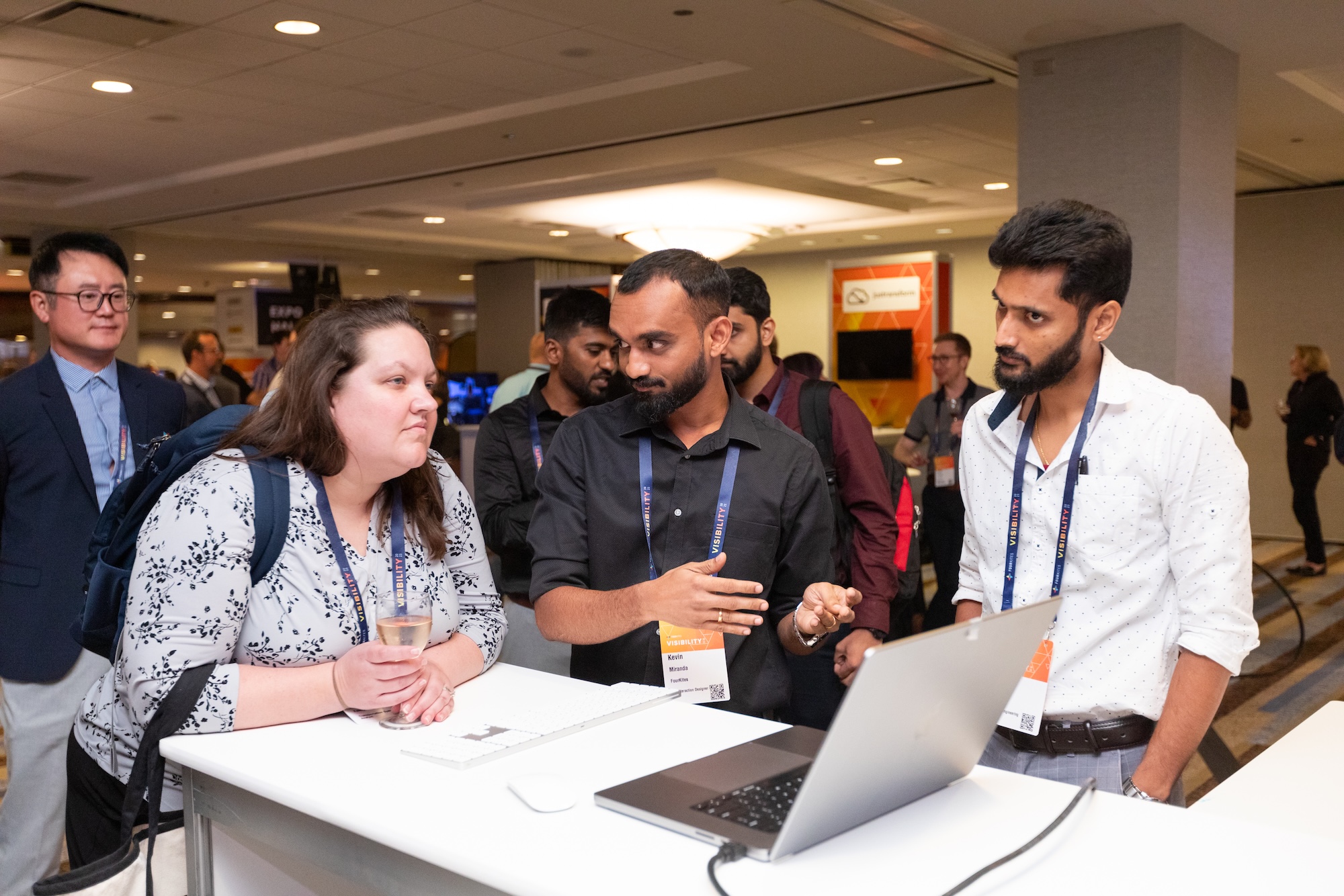 A team member demonstrates My Workspace to conference attendees at a booth.